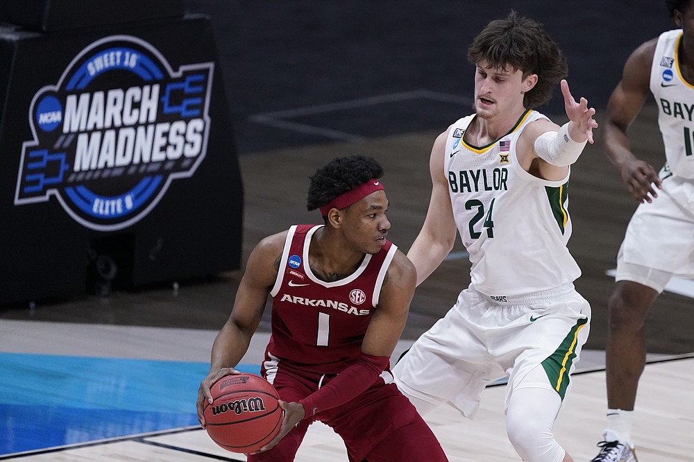 Arkansas guard JD Notae (1) protects the ball from Baylor guard Matthew Mayer (24) during the first half of an Elite 8 game in the NCAA men's college basketball tournament at Lucas Oil Stadium, Monday, March 29, 2021, in Indianapolis. (AP Photo/Darron Cummings)