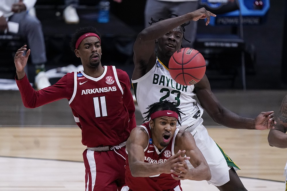 Arkansas guard Moses Moody, center, and teammate guard Jalen Tate (11) battle for a loose ball with Baylor forward Jonathan Tchamwa Tchatchoua (23) during the second half of an Elite 8 game in the NCAA men's college basketball tournament at Lucas Oil Stadium, Monday, March 29, 2021, in Indianapolis. (AP Photo/Michael Conroy)