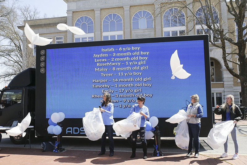 Vickie Price (from left), DesaRae Crouch, Holly Clarke and Carolyn Shewmaker release dove balloons, Friday, April 2, 2021 at the downtown square in Bentonville. The Children's Advocacy Center of Benton County Pinwheels for Prevention kicked off Child Abuse Awareness Month with speakers and an honorary dove release in remembrance of children lost to abuse in the community. Check out nwaonline.com/210403Daily/ for today's photo gallery. 
(NWA Democrat-Gazette/Charlie Kaijo)