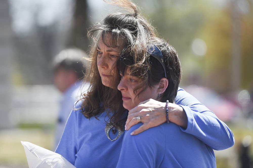 Vickie Price (from left) and DesaRae Crouch embrace, Friday, April 2, 2021 at the downtown square in Bentonville. The Children's Advocacy Center of Benton County Pinwheels for Prevention kicked off Child Abuse Awareness Month with speakers and an honorary dove release in remembrance of children lost to abuse in the community. Check out nwaonline.com/210403Daily/ for today's photo gallery.
(NWA Democrat-Gazette/Charlie Kaijo)