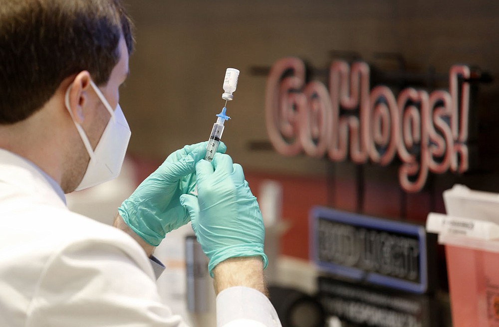 Matt Calhoun, a fourth year pharmacy student at the University of Arkansas for Medical Sciences Northwest College of Pharmacy, prepares a covid-19 vaccination shot Thursday, April 1, 2021, during an open covid-19 vaccination clinic hosted by the Northwest Arkansas Council in collaboration with the region's health care systems at Donald W. Reynolds Razorback Stadium on campus of the University of Arkansas in Fayetteville. Check out nwaonline.com/210403Daily/ and nwadg.com/photos for a photo gallery.
(NWA Democrat-Gazette/David Gottschalk)