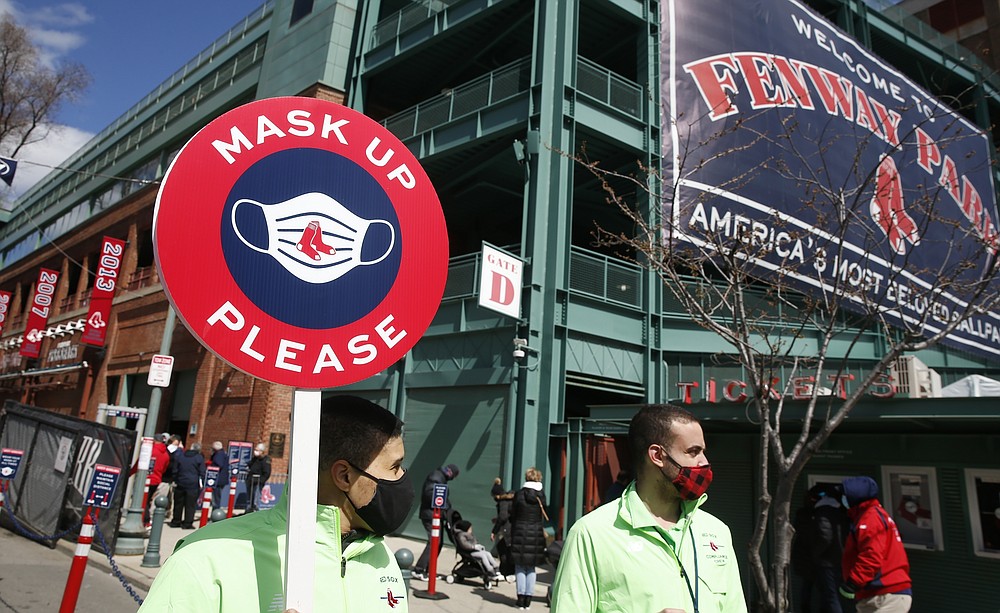 Members of the Boston Red Sox health compliance crew stand at the entrance to Fenway Park before an opening day baseball game between the Red Sox and the Baltimore Orioles, Friday, April 2, 2021, in Boston. (AP Photo/Michael Dwyer)