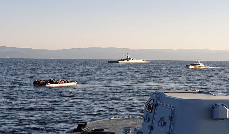 In this photo provided by the Hellenic Coast Guard and taken from a vessel shows a dinghy with migrants, left, with Turkish ships in the background, in the narrow stretch of water between the eastern Greek island of Lesbos and the Turkish coast on Friday, April 2, 2021. Greece is reporting a series of incidents with the Turkish coast guard in the narrow stretch of water between the eastern Greek island of Lesbos and the Turkish coast, at a time of generally testy relations between the two neighbors and NATO allies. The Greek coast guard said three incidents occurred Friday morning northeast of Lesbos, an island on the main migrant smuggling route from Turkey to Greece. It said two involved Turkish coast guard vessels escorting or pushing dinghies carrying migrants toward Greek territorial waters. There was no immediate reaction from Turkish authorities. Turkey and Greece have long traded accusations over the migration issue. (Hellenic Coast Guard via AP)