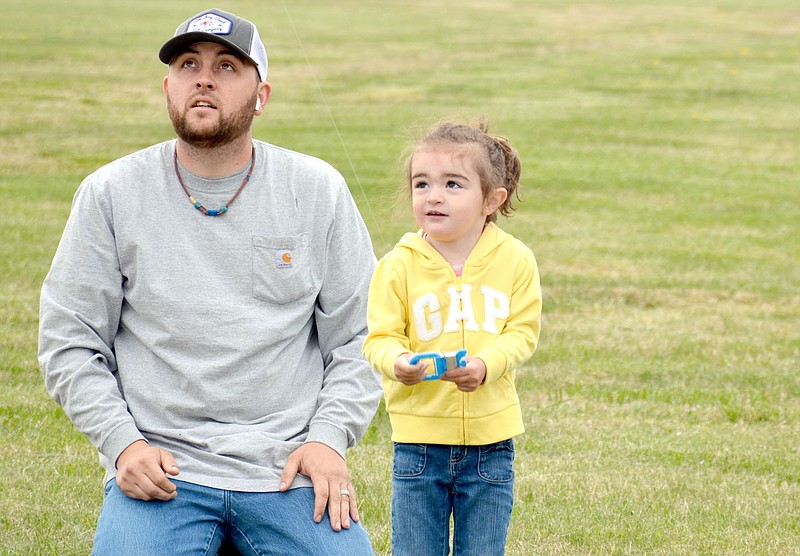 Marc Hayot/Herald-Leader Stephen Robbins (left), watches as his daughter Peaton flies her kite during Kite Day which was held from 10 a.m. to 12 p.m. on Saturday at the Siloam Springs Municipal Airport. “We’re just excited to be able to host another great outdoor event for families,” said Recreation Coordinator Ashley Davis. Along with kites The city provided a kite making tent for those who did not bring their own kites as well as different vehicles which kids could touch and play in. The vehicles offered included an ambulance, police vehicle and several construction vehicles used by the street department. There was also an airplane for people to touch and take a picture with but could be played in. The final count of attendees was approximately 350, Davis said.