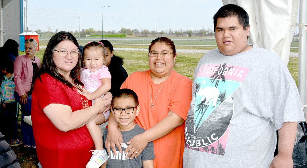 Marc Hayot/Herald-Leader Arlene Pear (left), Kelsey Vann, Mario Pineda Jr., Stacie Pineda and Ron Vann pose for a picture while making their kites at the kite making tent provided by the city on Kite Day.