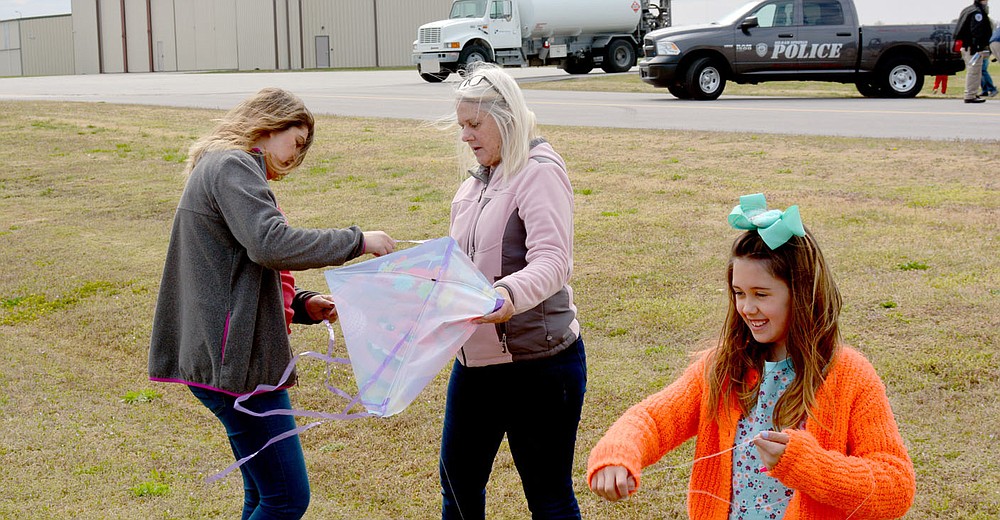 Marc Hayot/Herald-Leader Kelly Quick (left). and Julie Mitchell works fix a kite as Sophia Bedlin attempts to fly her kite during Kite Day.