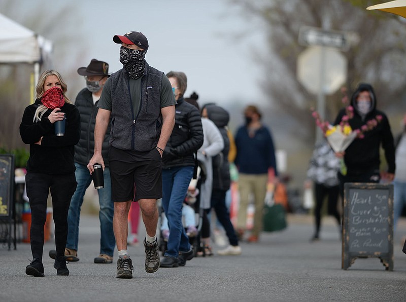 Patrons walk Saturday, April 3, 2021, while visiting the Fayetteville Farmers√ï Market on the Fayetteville downtown square. Fayetteville joins Rogers in continuing to require the wearing of masks in certain places despite the statewide mask mandate being lifted by Gov. Asa Hutchinson. Visit nwaonline.com/210404Daily/ for today's photo gallery. 
(NWA Democrat-Gazette/Andy Shupe)