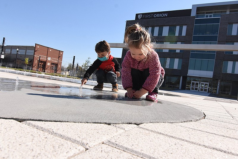 Zachary Slagle, 4, and his sister Leah, 3, play with the water feature at Argenta Plaza on Friday, April 2, 2021 in North Little Rock.
(Arkansas Democrat-Gazette/Staci Vandagriff)