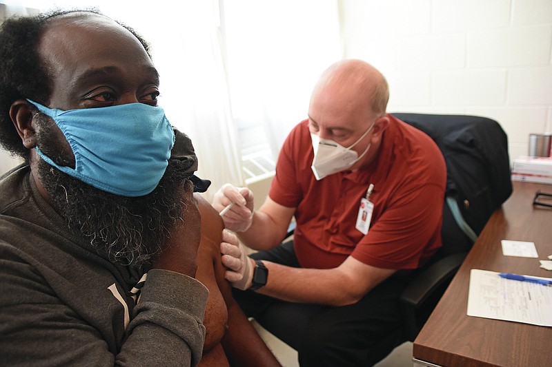 Ronald Gilbert (left) receives a shot of Johnson & Johnson coronavirus vaccine from Sedley Tomlinson, a section chief with the Arkansas Department of Health, on Thursday, April 1, 2021 at the Little Rock Compassion Center.
(Arkansas Democrat-Gazette/Staci Vandagriff)