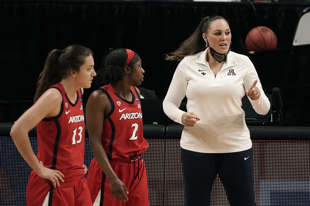 Arizona guard Helena Pueyo (13) and guard Aari McDonald (2) talk with head coach Adia Barnes, right, during the first half of the championship game against Stanford in the women's Final Four NCAA college basketball tournament, Sunday, April 4, 2021, at the Alamodome in San Antonio. (AP Photo/Morry Gash)