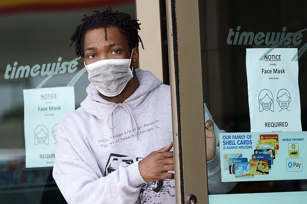 FILE - A man leaves a convenience store while wearing a required face mask in Houston, in this Thursday, June 25, 2020, file photo. Although nearly a fifth of U.S. states don't require people to wear masks to protect against COVID-19, some businesses are requiring employees and customers to be masked on their premises. (AP Photo/David J. Phillip, File)