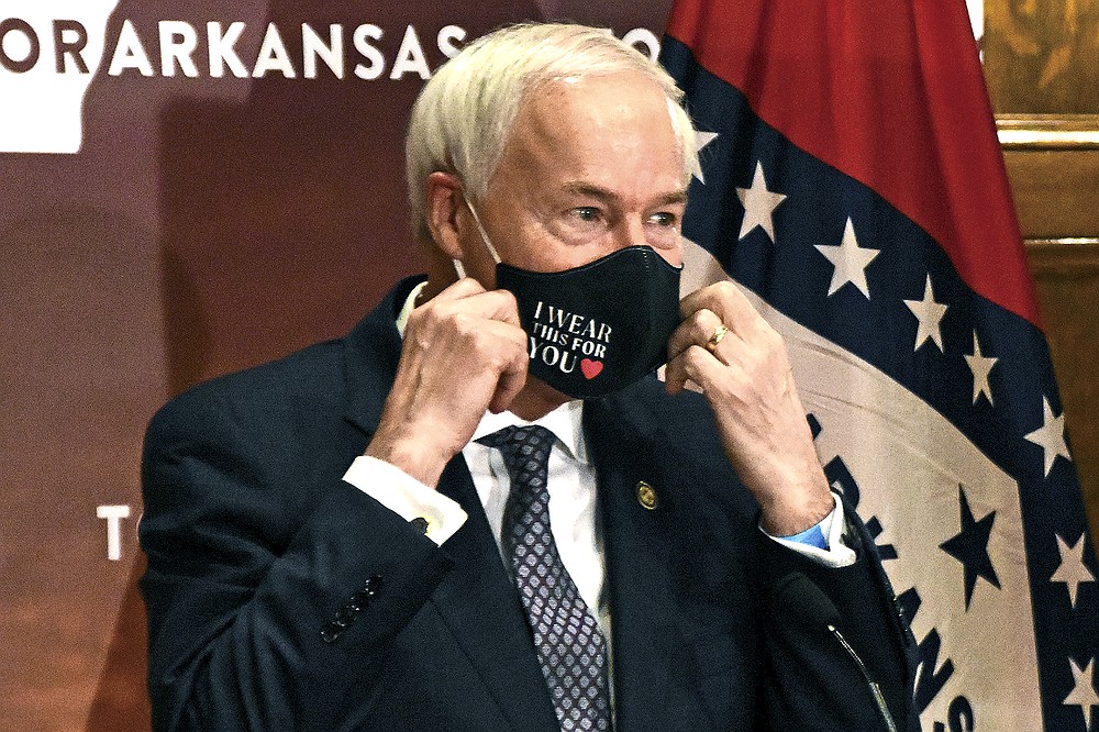 FILE - In this July 20, 2020 file photo, Arkansas Gov. Asa Hutchinson removes his mask before a briefing at the state capitol in Little Rock. Gov. Hutchinson on Monday, April 5, 2021 vetoed legislation that would have made his state the first to ban gender confirming treatments or surgery for transgender youth. (Staci Vandagriff/The Arkansas Democrat-Gazette via AP, File)
