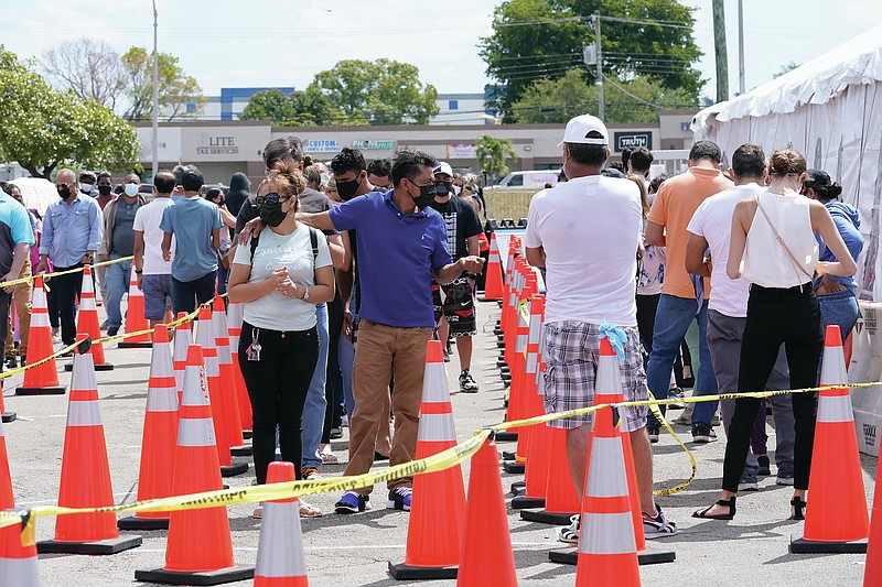 People wait in line to receive a COVID-19 vaccine at a FEMA vaccination center at Miami Dade College, Monday, April 5, 2021, in Miami. Any adult in Florida is now eligible to receive the coronavirus vaccine. In addition, the state announced that teens ages 16 and 17 can also get the vaccine with parental permission. (AP Photo/Lynne Sladky)