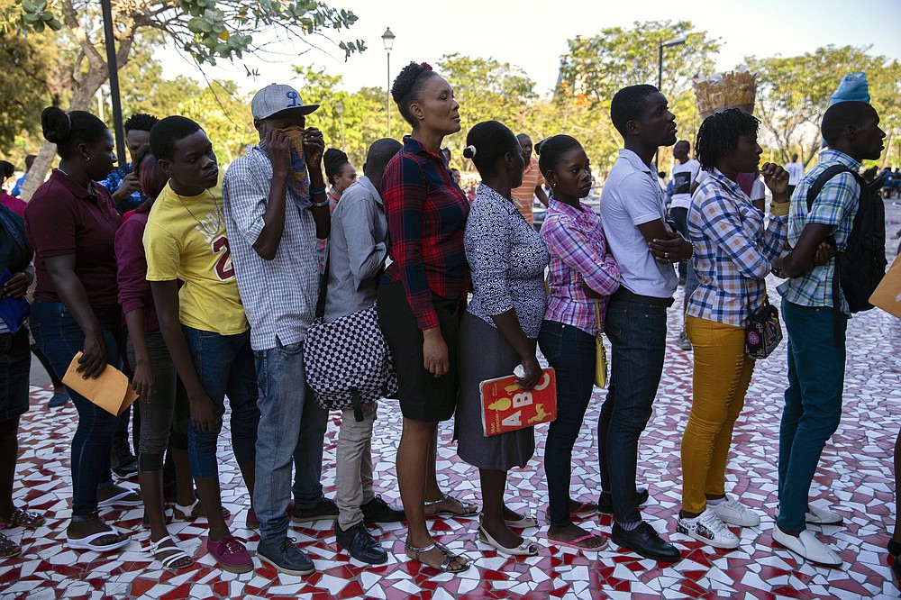 FILE - In this March 24, 2020 file photo, people line up at a government office for national identification cards before it potentially closes amid measures to contain the spread of the new coronavirus in Port-au-Prince, Haiti. (AP Photo/Dieu Nalio Chery, File)