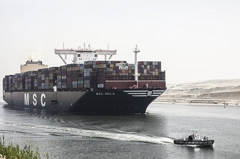 A container ship passes through Suez Canal, Egypt, Tuesday, April 6, 2021. The Suez Canal chief said that authorities are negotiating a financial settlement with the owners of a massive vessel that blocked the crucial waterway for nearly a week. (AP Photo/Mohamed Elshahed)