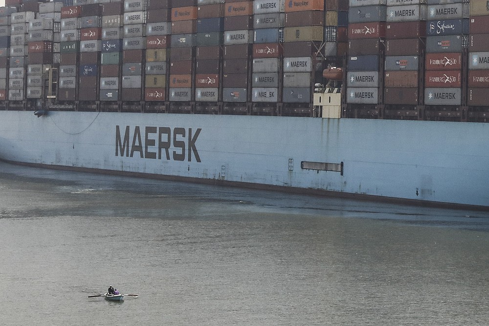 A container ship passes through Suez Canal, Egypt, Tuesday, April 6, 2021. The Suez Canal chief said that authorities are negotiating a financial settlement with the owners of a massive vessel that blocked the crucial waterway for nearly a week. (AP Photo/Mohamed Elshahed)