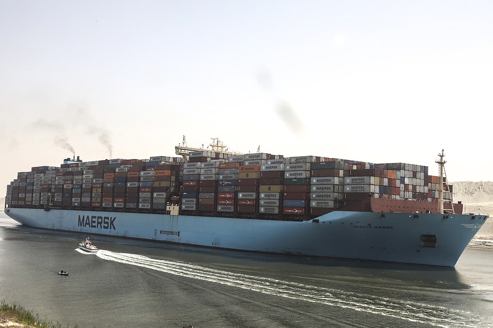 A container ship passes through Suez Canal, Egypt, Tuesday, April 6, 2021. The Suez Canal chief said that authorities are negotiating a financial settlement with the owners of a massive vessel that blocked the crucial waterway for nearly a week. (AP Photo/Mohamed Elshahed)
