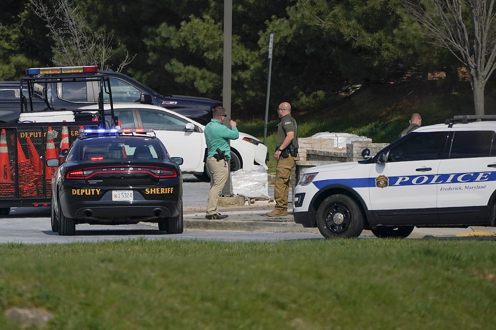 Police talk near the scene of a shooting at a business park in Frederick, Md., Tuesday, April 6, 2021. (AP Photo/Julio Cortez)
