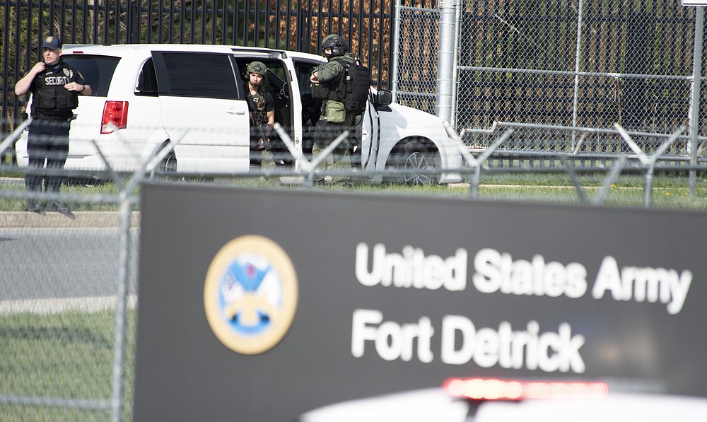 Members of the Frederick Police Department Special Response Team prepare to enter Fort Detrick at the Nallin Farm Gate in a convoy of vans and sedans, following a shooting in the Riverside Tech Park, near the Royal Farms on Monocacy Boulevard, Tuesday morning, April 6, 2021, in northeast Frederick, Md. Authorities say a Navy medic shot and critically wounded two people at a Maryland business park before fleeing to the Fort Detrick Army base, where he was shot and killed. (Graham Cullen/The Frederick News-Post via AP)