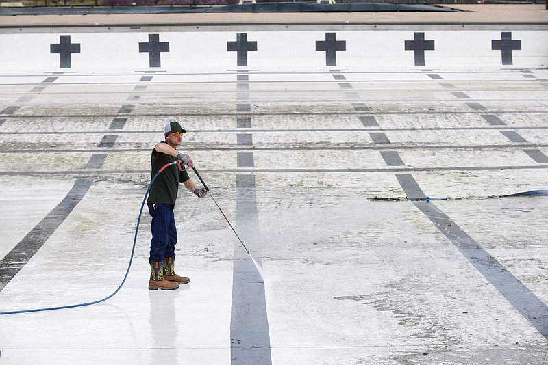 Johnny Kincheloe with Bentonville Parks and Recreation Department power washes a pool on Tuesday at the Melvin Ford Aquatic Center inside Memorial Park in Bentonville. The aquatic center features a 50-meter competition pool, diving area with diving boards and a wading pool with a rain-drop fountain feature. Information about the 2021 pool season will be available soon, says the city's website, bentonvillear.com. 
(NWA Democrat-Gazette/Flip Putthoff)