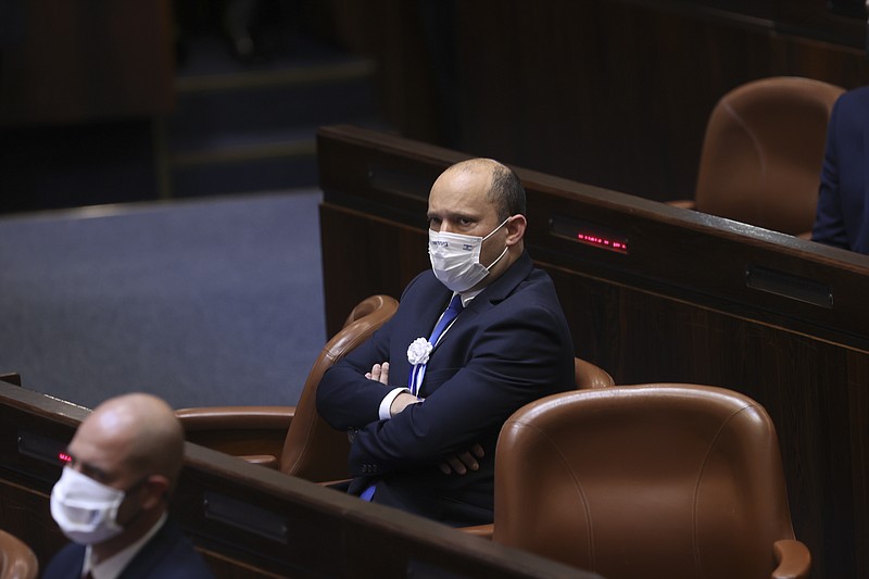 Israeli Knesset member Naftali Bennett from the Yamina party, center, attends the swearing-in ceremony for Israel's 24th government, at the Knesset, or parliament, in Jerusalem, Tuesday, April 6, 2021. The ceremony took place shortly after the country's president asked Netanyahu to form a new majority coalition, a difficult task given the deep divisions in the fragmented parliament. (Alex Kolomoisky/Pool via AP)