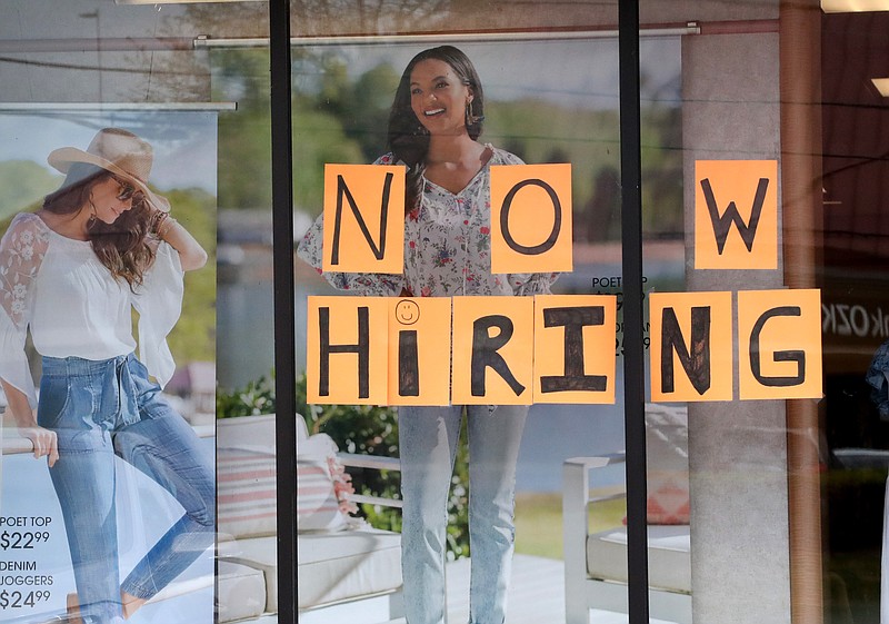 A now hiring sign is posted in a store front window in the 4000 block of Central Ave.,  Tuesday, April 6, 2021. Photo by Richard Rasmussen of The Sentinel-Record