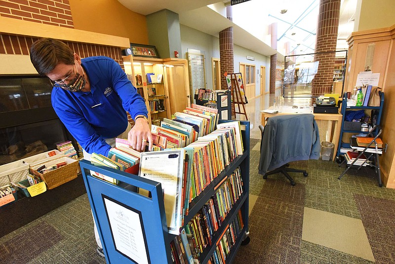 Chuck Pribbernow, a volunteer at the Bentonville Public Library, sorts books on Wednesday Feb. 24 2021 at Friends Book Store inside the library. Bentonville residents will vote April 13 on an extension of the city's 1% sales tax. 
(NWA Democrat-Gazette/Flip Putthoff)
