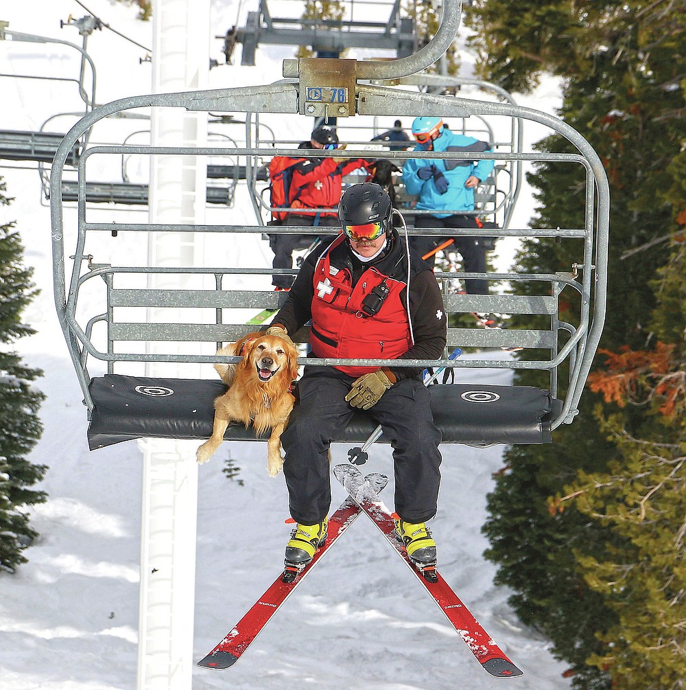 Ski patrol dog Buster rides the lift with his handler, patroller Andrew Pinkham, at Sugar Bowl Resort in Norden, Calif. on March 17, 2021. Rescue dogs at Lake Tahoe ski resorts receive specialized training to rescue people from avalanches in Nevada and California. They're trained to detect human scents, find buried clothes and rescue people sunk 10 to 12 feet (3 to 3.7 meters) in the snow. (Jason Bean/The Reno Gazette-Journal via AP)