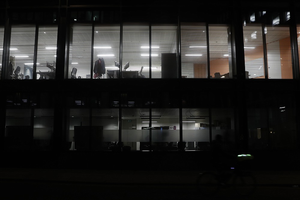 Lights shine from empty offices in the Barbican area of the City of London, Saturday, March 6, 2021. When the pandemic struck, about 540,000 workers vanished from London's financial hub almost overnight. The area known as "the City" became a ghost town as many people began working from home. A year on, most haven't returned to the business hub. (AP Photo/Alastair Grant)