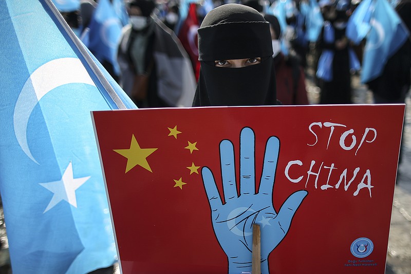 A protester from the Uyghur community living in Turkey holds up an anti-China placard during a protest against the visit of China's Foreign Minister Wang Yi to Turkey, in Istanbul, Thursday, March 25, 2021. Hundreds protested against the Chinese official visit and what they allege is oppression by the Chinese government to Muslim Uyghurs in the far-western Xinjiang province. 
Photo by Emrah Gurel via The Associated Press