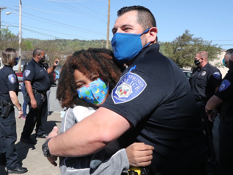 Rosalyn Baldwin, 11, of Hammond, La., gives Hot Springs police Officer 1st Class Omar Cervantes a hug during a visit to the police station Thursday as part of her ongoing mission to “spread love” to police around the country. - Photo by Richard Rasmussen of The Sentinel-Record