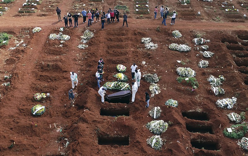 The Associated Press
Cemetery workers wearing protective gear lower the coffin of a person who died from complications related to COVID-19 into a gravesite at the Vila Formosa cemetery in Sao Paulo, Brazil, on Wednesday.