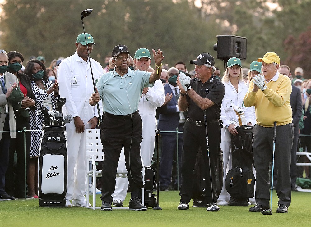 Honorary starter Lee Elder, left, gestures as he is introduced and applauded by honorary starters Gary Player and Jack Nicklaus, right, before the ceremonial tee shots to begin the Masters golf tournament at Augusta National Golf Club in Augusta, Ga., Thursday, April 8, 2021. (Curtis Compton/Atlanta Journal-Constitution via AP)