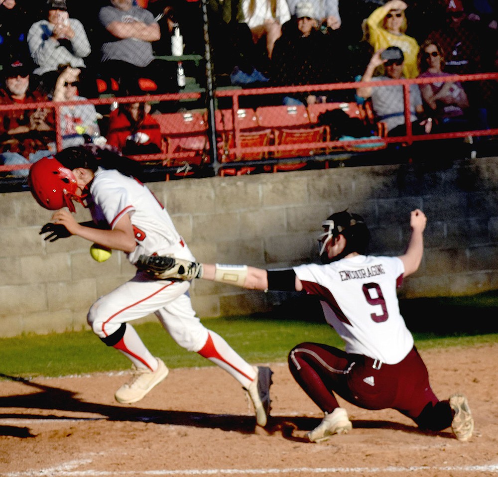 MARK HUMPHREY ENTERPRISE-LEADER/Farmington sophomore Skyler Riddle's batting helmet comes off as she runs through the attempted tag of Gentry pitcher Kyleigh Wheaton covering home plate on a passed ball.
