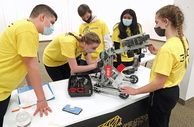 Bentonville High School robotic team members, from left, Jackson Clupny, Mackenzie Jackson, Wyatt Marsiglia, Sravya Ravipati and Maya Ellgass, get their robot ready for competition at Uptown Hot Springs on Friday. - Photo by Richard Rasmussen of The Sentinel-Record