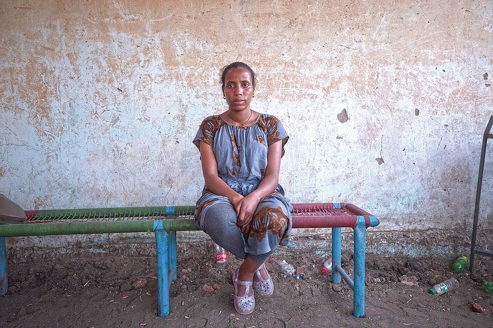 Elsa Tesfa Berhe, 26, center, a reproductive health official from Adwa, sits on a bench hours after arriving from Humera to Hamdayet, eastern Sudan, near the border with Ethiopia, on March 15, 2021. Reusing gloves and rationing water, Berhe treated women secretly after Eritrean soldiers swept through health centers, looting even the beds and telling patients to leave. As she snuck out to deliver babies and treat the wounded, she saw people trying to bury bodies at the risk of being shot, or pouring alcohol on corpses in an attempt to hide the smell. (AP Photo/Nariman El-Mofty)