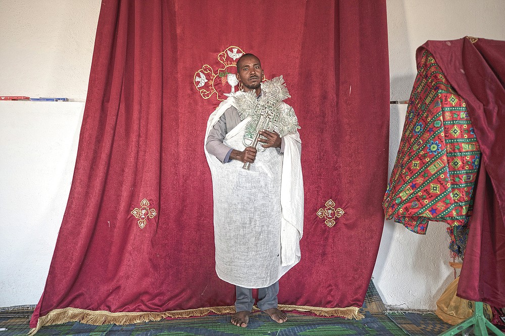 Ordained priest Berhane Debesu, 34, a Tigrayan refugee from Humera, stands with a cross at the church in Hamdayet, eastern Sudan, near the border with Ethiopia, on March 15, 2021. What started as a political dispute in one of Africa’s most powerful and populous countries has turned into a campaign of what is being called ethnic cleansing against minority Tigrayans, according to AP interviews with 30 refugees in Sudan and dozens more by phone, along with international officials. (AP Photo/Nariman El-Mofty)