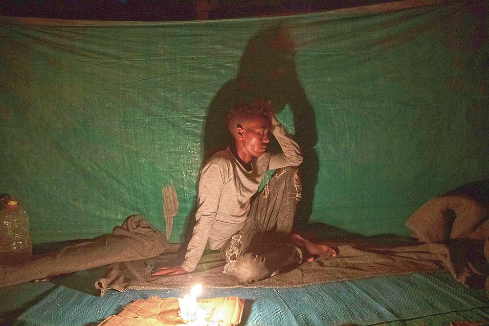 Abedom, a 25-year-old day laborer and Tigrayan refugee, sits for a portrait inside his friends' shelter in Hamdayet, eastern Sudan, near the border with Ethiopia, on March 16, 2021. Abedom spent three months roaming in mountains and rural villages. "It was normal to go a whole day without food. So many people were hungry. They loot everything, so if they take it all, how do I survive?" (AP Photo/Nariman El-Mofty)