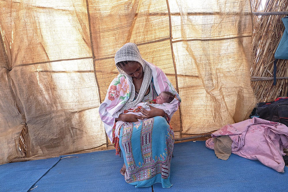 Lemlem Gebrehiwet, a 20-year-old Tigrayan refugee, holds her 3-day-old daughter, Semhal, in their shelter in Hamdayet, eastern Sudan, near the border with Ethiopia, on March 16, 2021. Other Tigrayans were turned away because of who they were. "They started distributing new ID cards in Bahkar but only for Amhara and Wolkait," said Gebrehiwet, who fled while heavily pregnant and gave birth three days after reaching Sudan. (AP Photo/Nariman El-Mofty)