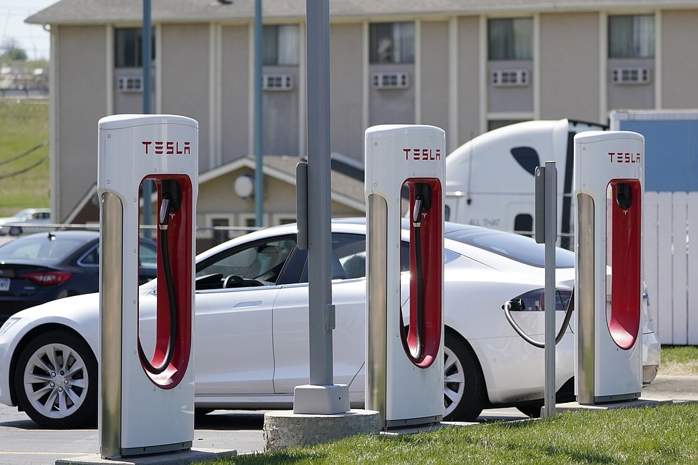 A Tesla charges at a station in Topeka, Kan., Monday, April 5, 2021. The president and the auto industry maintain the nation is on the cusp of a gigantic shift to electric vehicles and away from liquid-fueled cars, but biofuels producers and some of their supporters in Congress aren’t buying it. They argue the U.S. should increase sales of ethanol and biodiesel, not abandon them. (AP Photo/Orlin Wagner)