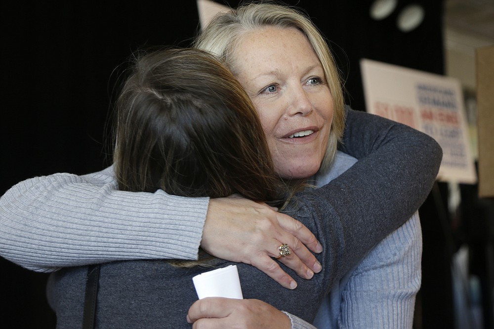 FILE - in this Oct. 22, 2013 file photo, Mount St. Mary school teacher then, Tippi McCullough, right, is hugged by a supporter after a Little Rock, Ark. The Catholic school teacher was allegedly told she would be fired from her job after she married her wife in New Mexico. A longtime abortion opponent who once opposed allowing gay couples to be foster parents, Arkansas Gov. Asa Hutchinson is the unlikeliest figure to complain about bills on the "culture wars" reaching his desk.But by vetoing a ban on gender confirming treatments for transgender youth, the Republican offered a rare rebuke to fellow conservatives who have been in overdrive this legislative session with bills targeting LGBTQ people, restricting abortion access and expanding gun rights. (AP Photo/Danny Johnston File)