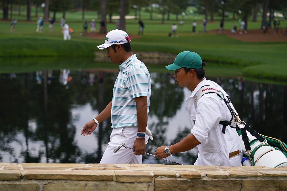 Hideki Matsuyama, of Japan, walks on the 15th hole with his caddie Shota Hayafuji during the third round of the Masters golf tournament on Saturday, April 10, 2021, in Augusta, Ga. (AP Photo/Matt Slocum)