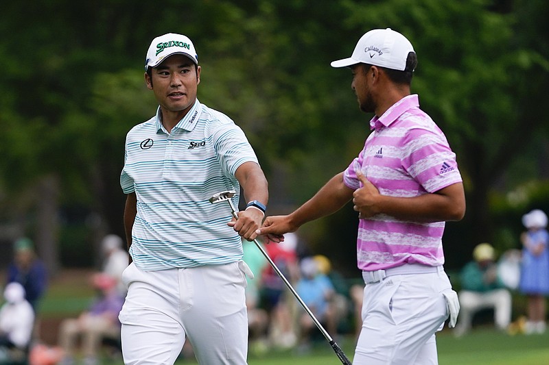 Hideki Matsuyama, of Japan, and Xander Schauffele, right, congratulate themselves after their eagles on the 15th hole during the third round of the Masters Saturday in Augusta, Ga. - Photo by Matt Slocum of The Associated Press