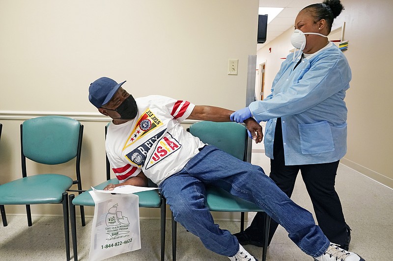 FILE - In this April 7, 2021, file photo, Wilbert Marshall, 71, left, pretends to be scared of receiving the COVID-19 vaccine from a nurse at the Aaron E. Henry Community Health Service Center in Clarksdale, Miss. Marshall, who was among a group of seniors from the Rev. S.L.A. Jones Activity Center for the Elderly who received their vaccinations, said he wanted the vaccination in order to stay safe and be able to visit with family without the constant fear of the virus. (AP Photo/Rogelio V. Solis)