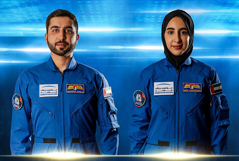 In this undated handout photograph from the United Arab Emirates' state-run WAM news agency, newly named Emirati astronauts Mohammed al-Mulla, left, and Noura al-Matroushi, right, pose for a photo. The United Arab Emirates named the next two astronauts in its space program Saturday, April 10, 2021, including the country's first female astronaut. (WAM via AP)