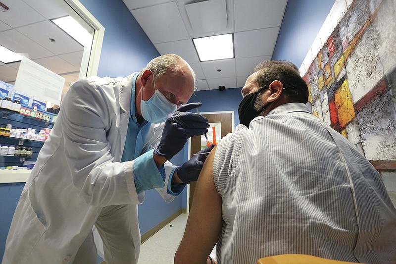 Pharmacist Edward "Burk" Buerkle gives Hugh Finkelstein his second dose of the Pfizer covid-19 vaccine on Friday, April 9, 2021, at Freiderica Pharmacy and Compounding in downtown Little Rock. (Arkansas Democrat-Gazette/Thomas Metthe)