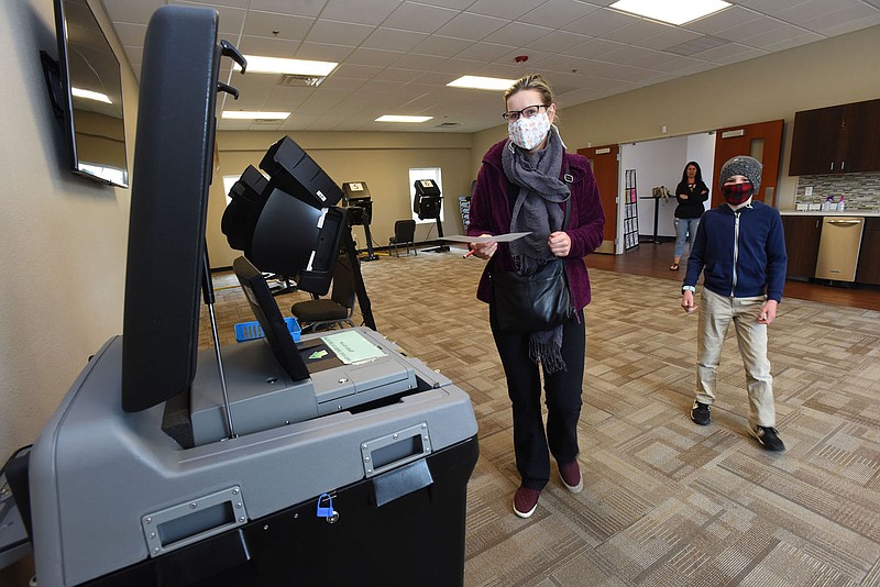 Alexandra Odesskiy (cq), casts her ballot on Tuesday April 13 2021 during the Bentonville bond issue election. She brought her son, Daniel (right), 9, with her to watch the voting process at First Landmark Missionary Baptist church in Bentonville. Go to nwaonline.com/210414Daily/ to see more photos.
(NWA Democrat-Gazette/Flip Putthoff)