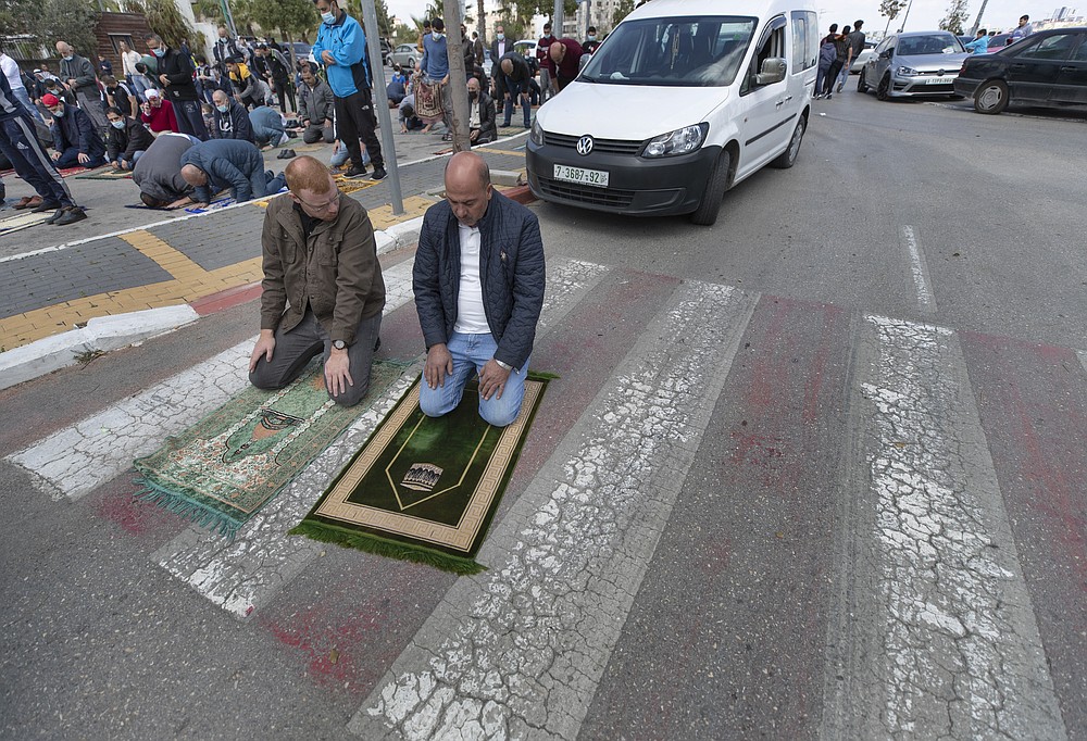FILE - In this Friday, April 9, 2021 file photo, Palestinians practice outdoor social distancing while attending the last Friday prayers ahead of the upcoming Muslim fasting month of Ramadan, in the West Bank city of Ramallah. Muslims are facing their second Ramadan in the shadow of the pandemic. Many Muslim majority countries have been hit by an intense new coronavirus wave. While some countries imposed new Ramadan restrictions, concern is high that the month’s rituals could stoke a further surge. (AP Photo/Nasser Nasser, File)