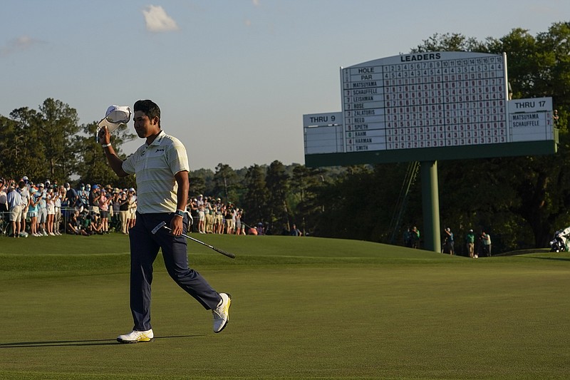 Hideki Matsuyama, of Japan, waves his cap after winning the Masters golf tournament on Sunday, April 11, 2021, in Augusta, Ga. (AP Photo/David J. Phillip)