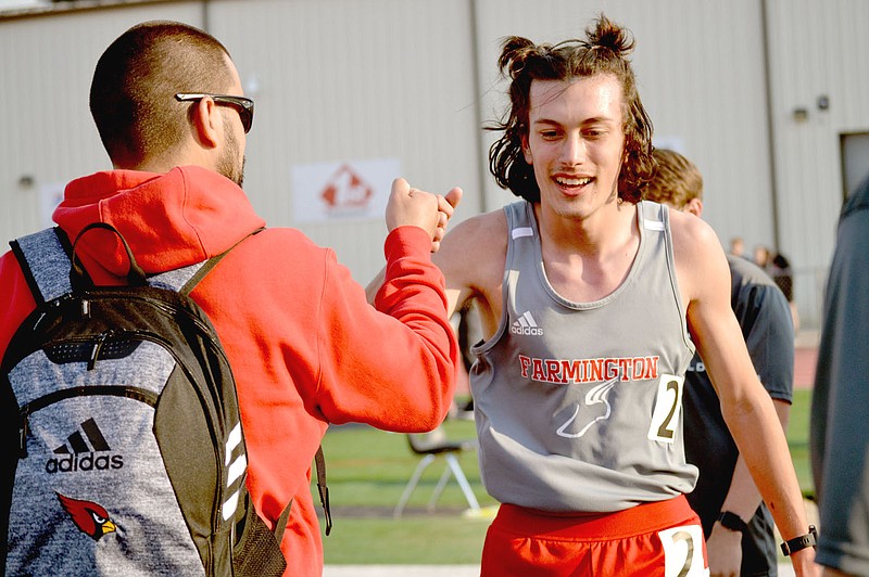 Annette Beard Special to the Enterprise-Leader/Farmington’s Mason Gansz receives congratulations from Farmington coach Greg Pair after winning the 1600 meter race with a time of 5:09.59 during the Blackhawk Relays hosted by Pea Ridge on Thursday.